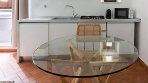A compact kitchen with white cabinets, a microwave, and a small countertop. - Daplace - Emilia Apartment (Roma)
