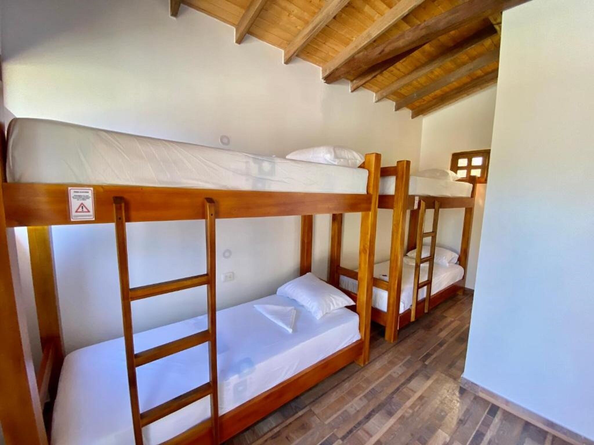 Letto a castello in una stanza con travi a vista al soffitto.