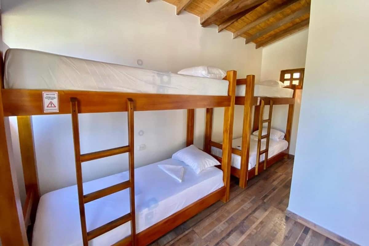 Stockbetten in einem Zimmer mit Holzbalken an der Decke.