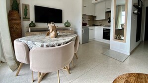 Un salon moderne avec une table à manger, un canapé et une cuisine en arrière-plan.