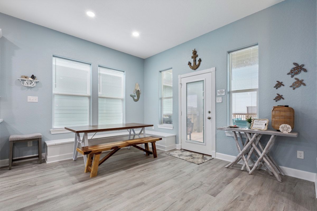 A room with a wooden bench, a small table, and a door with a glass panel.