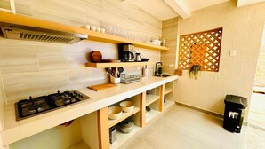 Eine moderne Küche mit Gasherd, Holzregalen und einem eingebauten Backofen.