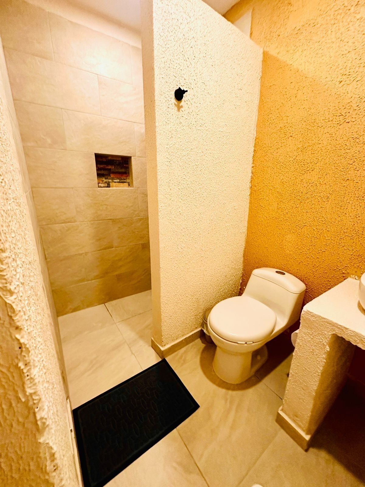 Een badkamer met toilet, wastafel en douchehoek.