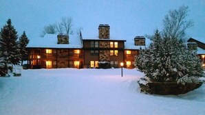 Ein großes, mehrstöckiges Holzhaus mit verschneitem Dach und mehreren Schornsteinen.
