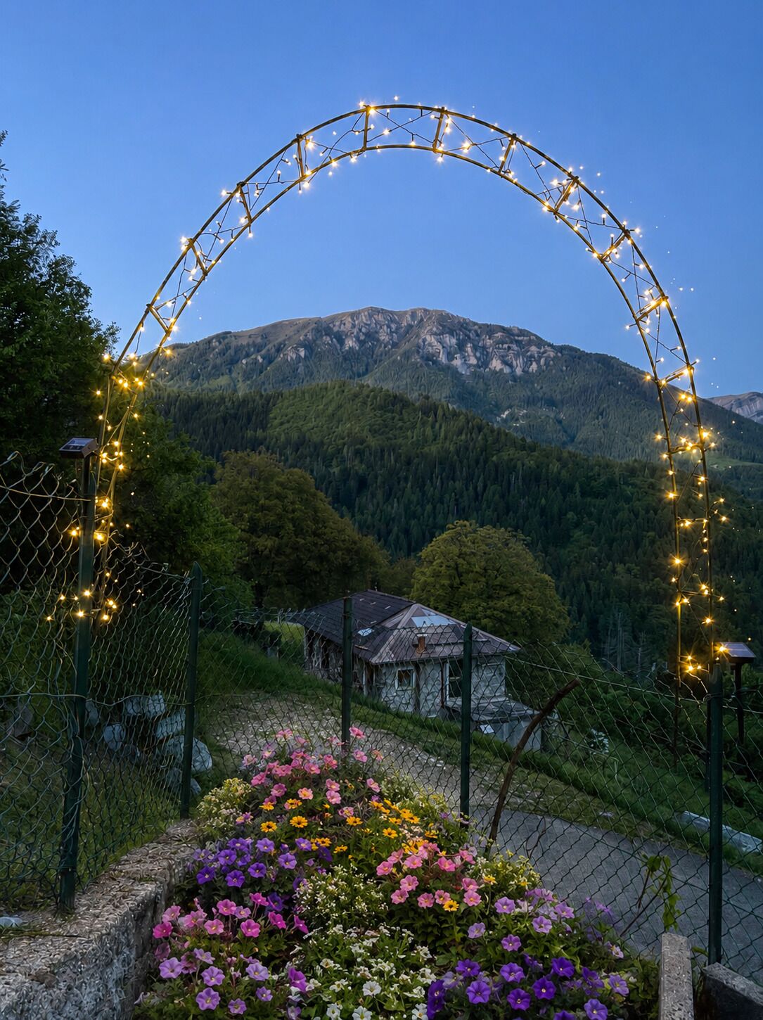 A mountainous landscape with a house and a decorative archway with lights.
