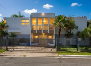 A modern two-story building with a flat roof, large windows, and a gated entrance. - Hidden Paradise w/ Pool (Guaynabo)