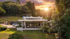 Un edificio moderno con tetto piatto, ampie finestre e una zona salotto all'aperto coperta.