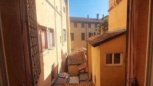 Une ruelle étroite, située entre des bâtiments aux toits couverts de tuiles et aux petites fenêtres.