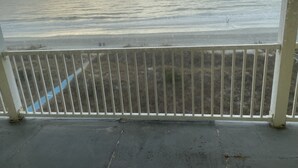 Ein Balkon mit Blick auf den Ozean und den Strand.