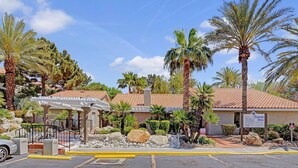 Ein Hotel mit überdachtem Außenbereich, Palmen und einem Schild mit der Aufschrift 'Flamingo Palms'.