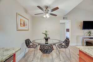 A dining area with a round glass table, four chairs, a ceiling fan, and a painting on the wall. - Las Vegas Condo minutes from the Strip, Team Mobile and Allegiant Stadium (Las Vegas)