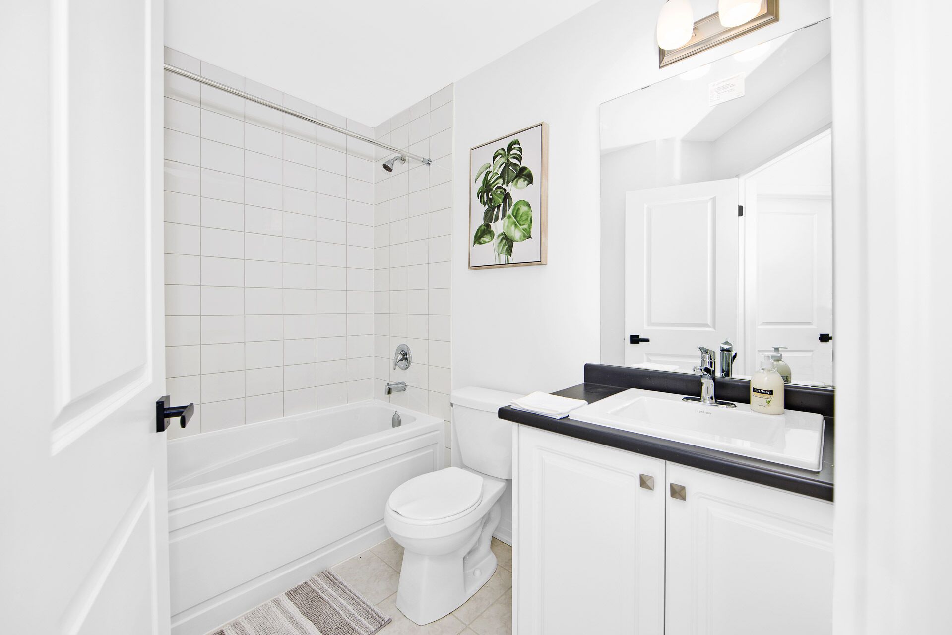 Een moderne badkamer met een bad, toilet en wastafel.
