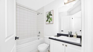 Une salle de bain moderne avec une baignoire, des toilettes et un lavabo.