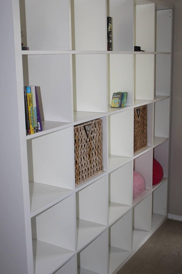 A white shelving unit with multiple compartments, some containing books and decorative items. - Charming Retreat in heart of Amarillo (Amarillo)