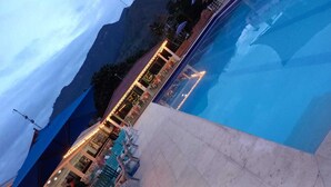 Un hotel con piscina, bar y vistas a las montañas.