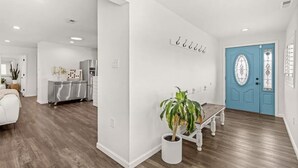 A modern interior with a kitchen, a dining area, and a blue door. - Seaside Breeze - 4BR 3BA 5 min. Walk to Beach (Kill Devil Hills)