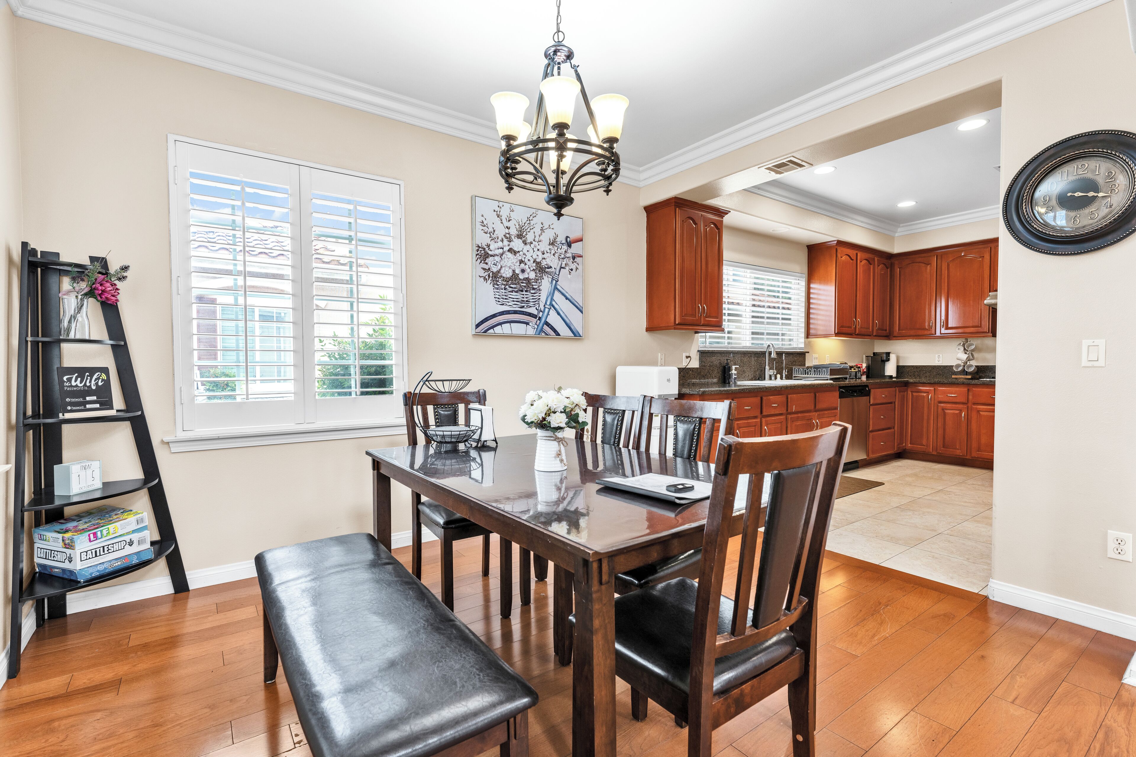 A spacious kitchen with wooden cabinets, a dining area with a table and chairs, and a chandelier.