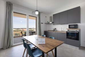 Een moderne keuken met grijze kastjes, een magnetron en een oven.
