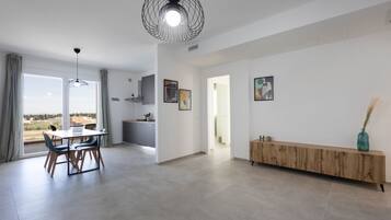 Ein modernes Interieur mit Essbereich, Küche und einem großen Fenster mit Blick.