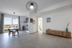 Een modern interieur met een eethoek, keuken en een groot raam met uitzicht.