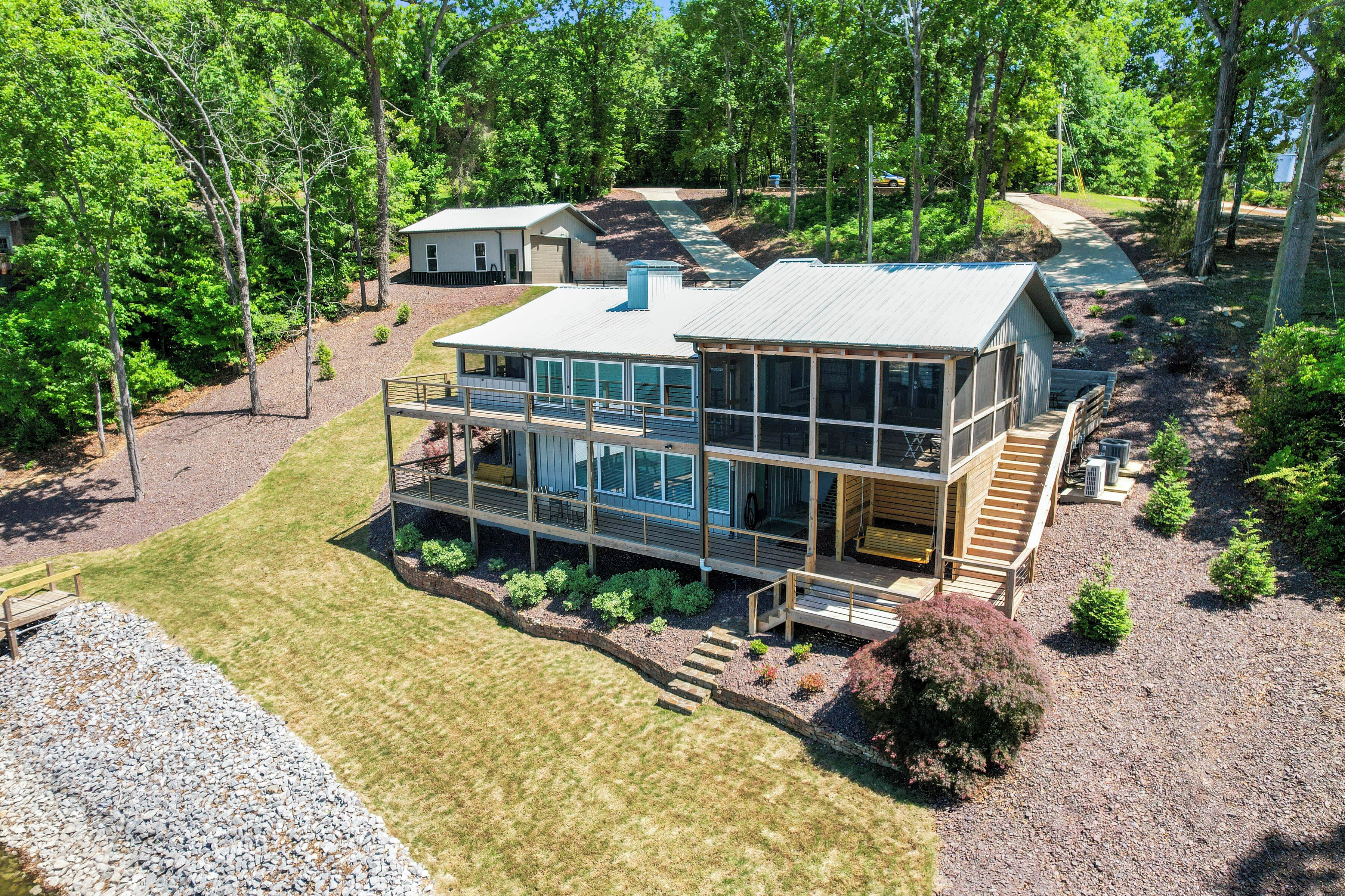 A modern two-story house with a large deck and a covered outdoor area.