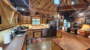 Une cuisine rustique avec des meubles en bois, un réfrigérateur en acier inoxydable et un plan de travail en bois.