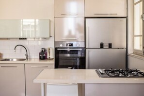 A modern kitchen with stainless steel appliances, a gas stove, and a built-in oven.
