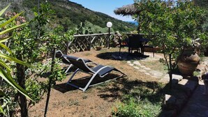 A patio with two lounge chairs, a table, and a pergola.