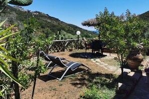 Un patio con dos sillones de descanso, una mesa y una pérgola.