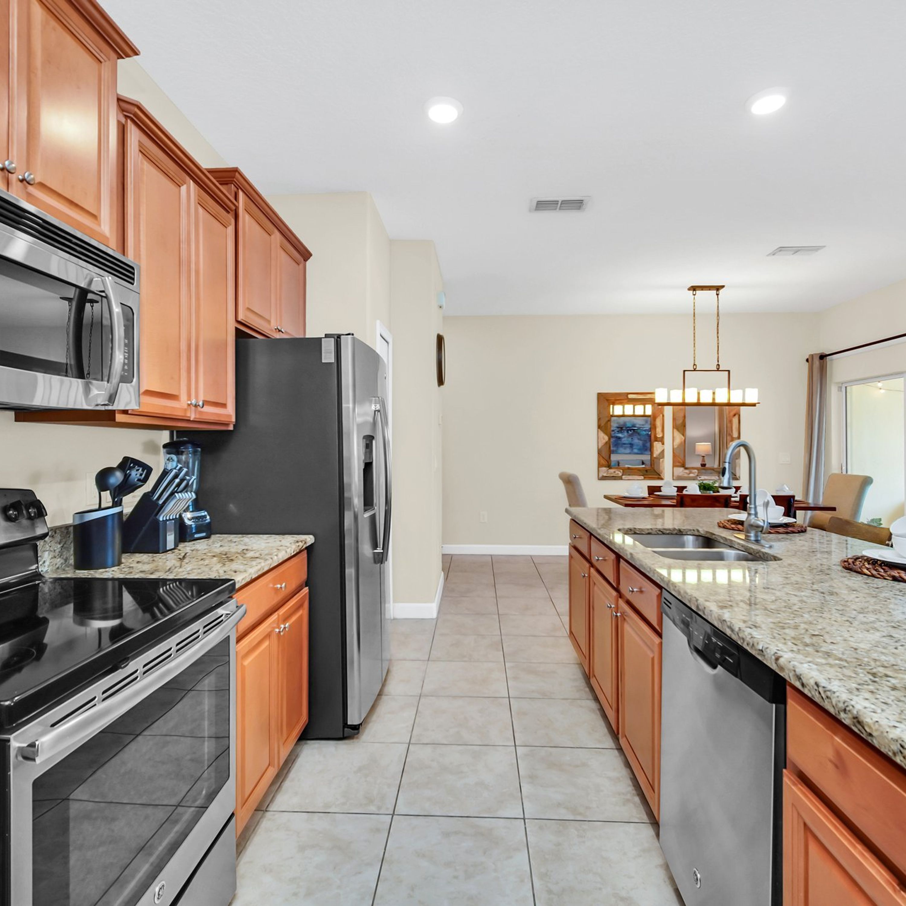 A modern kitchen with granite countertops, stainless steel appliances, and wooden cabinets.