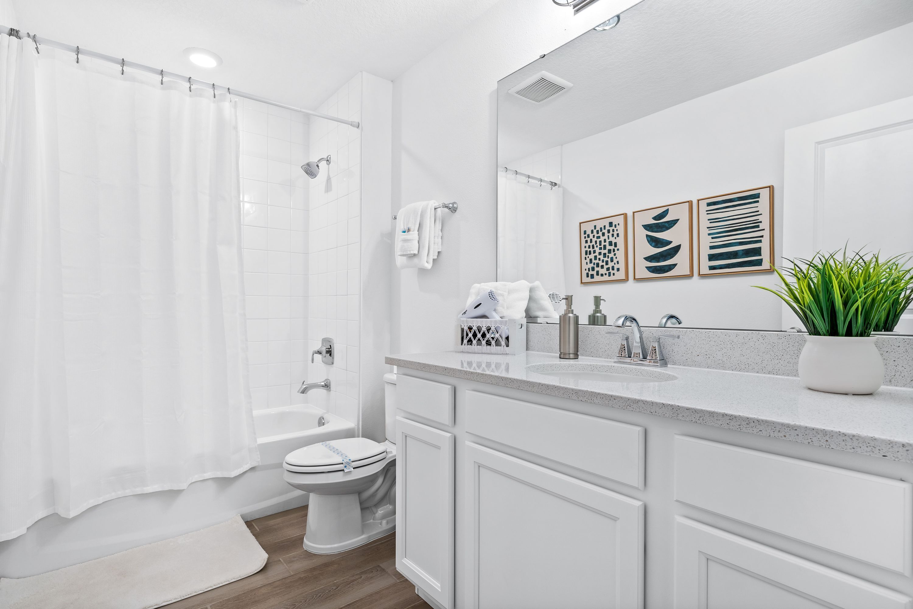 A modern bathroom with a shower, toilet, and sink.