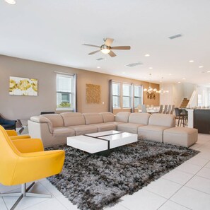 Una sala de estar moderna con un sofá modular, una mesa de centro y un sillón amarillo.