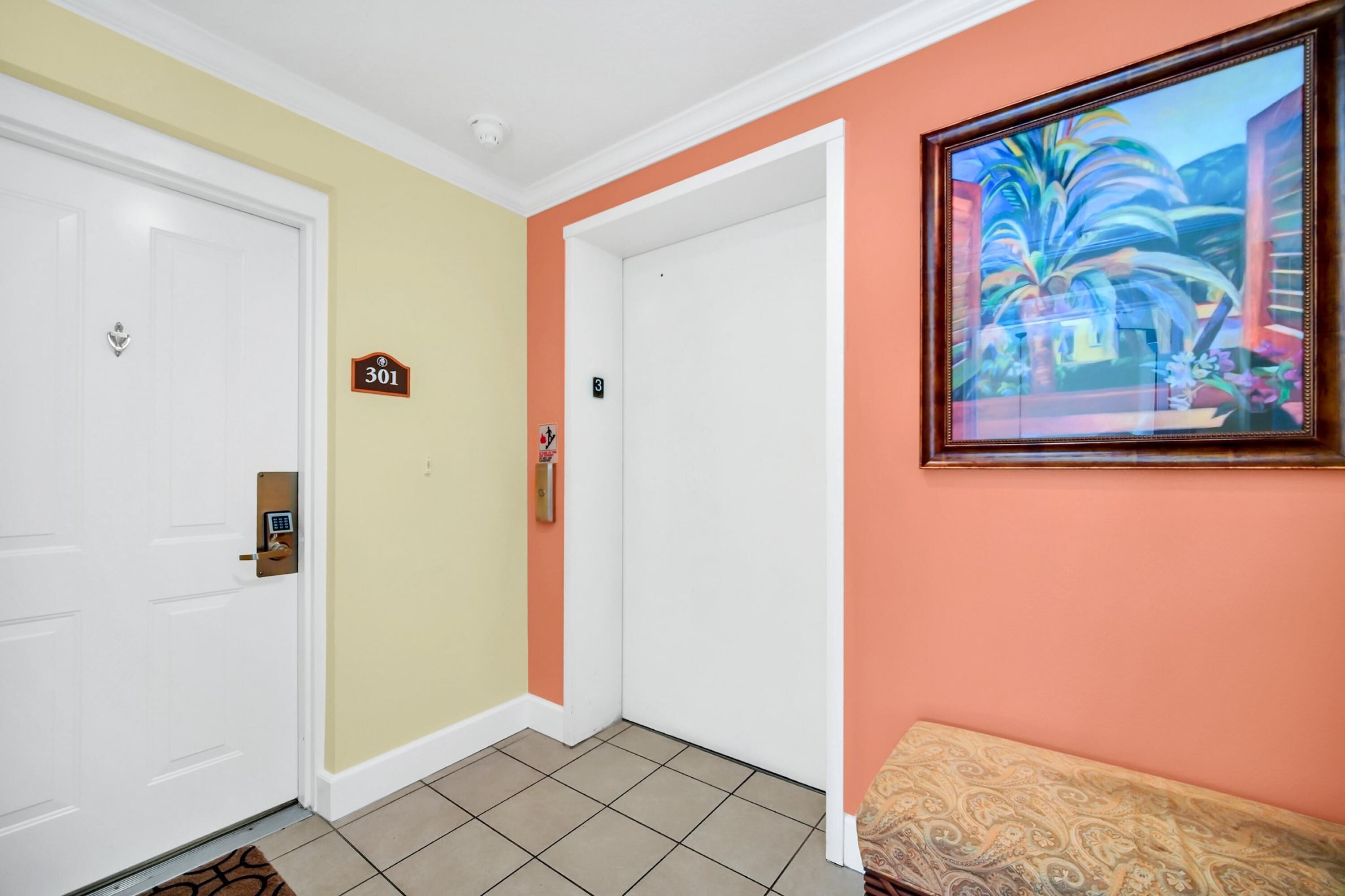 A hallway with a white door, a doorbell, and a number sign '301'.