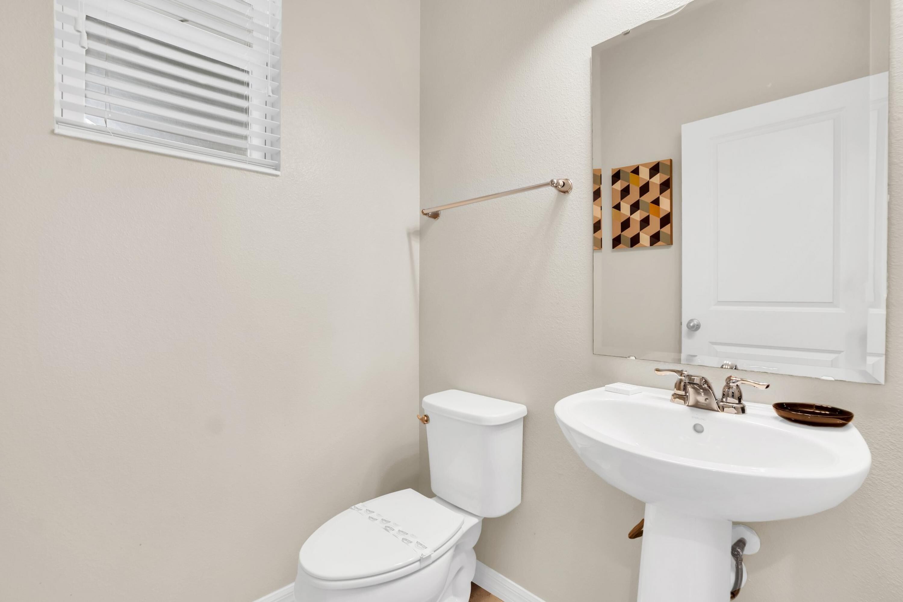 Ein Badezimmer mit Toilette, Waschbecken und Handtuchhalter.