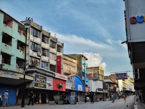 A street with various shops and buildings, including a sign for 'MOY'S' and a 'DEAL' sign.