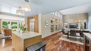 Een moderne keuken met een centraal eiland, houten kasten en een roestvrijstalen koelkast.