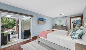 A bedroom with a bed, a dresser, and a large window. - Wilton Manors Stunning Gated Oasis (Fort Lauderdale)