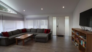 A modern living room with a sectional sofa, a coffee table, and a bookshelf.