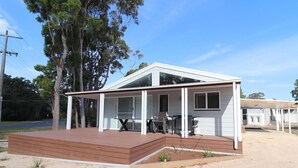 A single-story house with a covered porch and a small deck area.