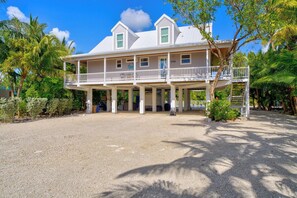 A two-story house with a balcony, surrounded by palm trees and a gravel driveway. - P35 - Spacious 4 bedroom, 3 bath home boasts generous harbor views (Marathon)