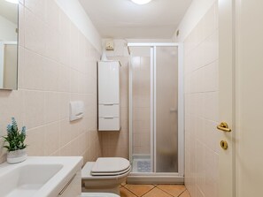Ein kleines Badezimmer mit Toilette, Waschbecken und Duschkabine.