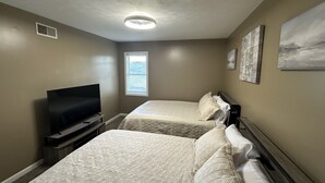 A hotel room with two beds, a television, a window, and artwork on the walls. - Retreat to my Beautiful Contemporary Home in the Mountain State (Morgantown)