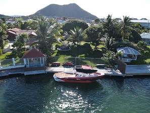 A marina with boats docked, surrounded by residential buildings and palm trees. - PARIS Waterfront Villas (Gros Islet)