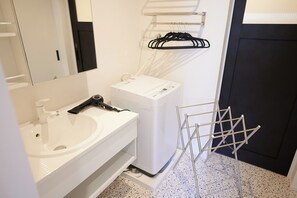 A modern bathroom with a white sink, a mirror, a white dryer, and a metal drying rack. - Private seaside house with private BBQ deck and projector for 6 pax / Awaji Hyōgo (Awaji)