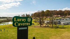 Luray-luolien opastekyltti, jonka alla on erillinen kyltti, joka osoittaa sisäänkäynnin.