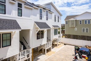 A multi-story residential building with a porch and a staircase leading to the entrance.