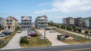 Un quartier résidentiel situé sur la côte, avec des immeubles à plusieurs étages, un parking et un ciel dégagé.