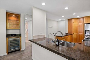 A modern kitchen with granite countertops, stainless steel appliances, and wooden cabinets.