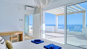 Ein Hotelzimmer mit Bett, Schreibtisch und Meerblick.