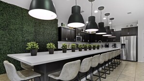 A modern kitchen with a long island, black pendant lights, and a green wall. - Sleeps 20 - Masterpiece Collection Ww101 (Kissimmee)